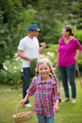 Familie im Garten, Mädchen mit leerem Korb