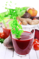 Glasses of beet juice with vegetables on wooden table closeup