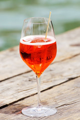 A glass of cocktail on a wood table on the beach