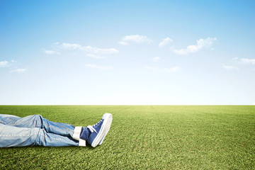 Lazy man lying on the grass doing nothing