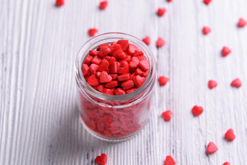 Colorful sprinkles on jar on table close-up