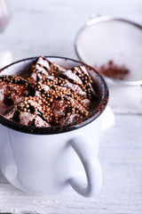 Mug of cocoa with marshmallows on wooden background