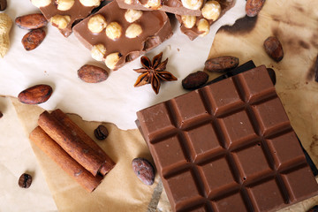 Chocolate with nuts and spices on paper, closeup