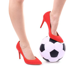 Female legs in red high heeled shoes with soccer ball isolated on white