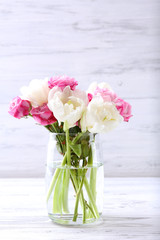 Bouquet of fresh roses and tulips on wooden background