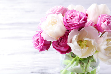 Bouquet of fresh roses and tulips on wooden background
