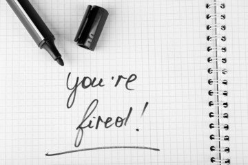 Message You're Fired on notebook with marker, closeup