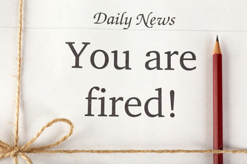 Message You're Fired on stack of newspapers, closeup
