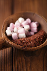 fine grated chocolate and marshmallow candy  in old spoon, woode