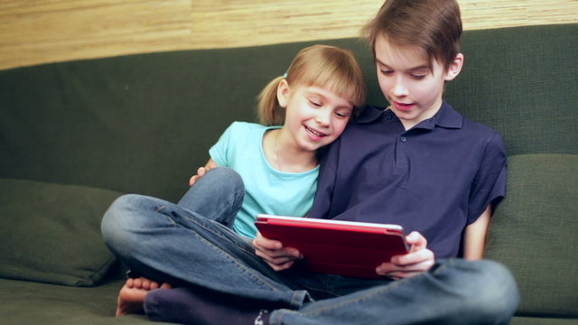 Siblings using a tablet computer panning