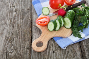 Cucumbers and tomatoes on a cutting board