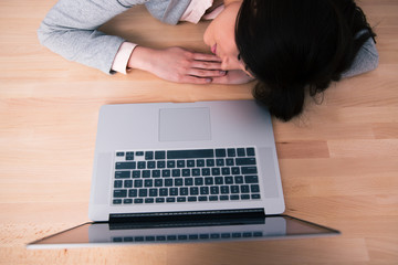 Woman sleeping on the table with laptop