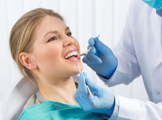 Pulp disease, root canal treatment. Young woman at dentist