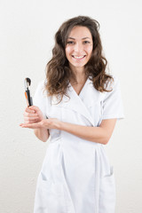 Nice and young professional beautician holding brushes