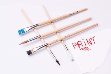 Paint word on a white sheet and paint brushes