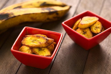 Fried slices of the ripe plantain in small red bowls © Ildi