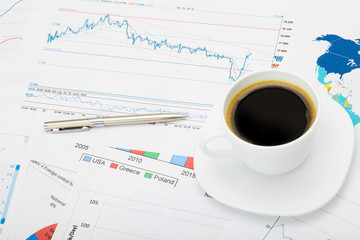 Coffee cup over different financial charts