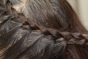 Hairdresser make braids on long hair