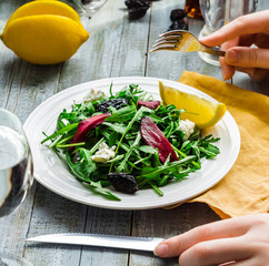 eating green salad with arugula, beets, goat cheese and olive oi