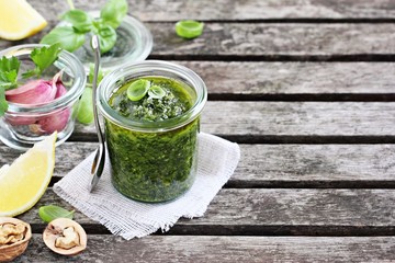Basil pesto on a rustic wooden table.Selective focus.