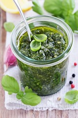 Basil pesto on a rustic wooden table.Selective focus.