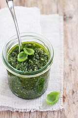 Basil pesto on a rustic wooden table.Selective focus.