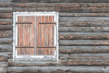 Closed shutters on a wooden chalet worn by the snow