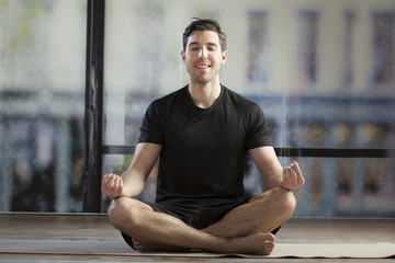 young man doing yoga in office