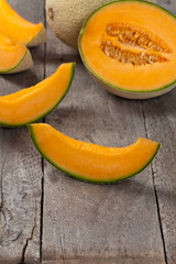 Fresh melons on old wooden background. Selective focus.
