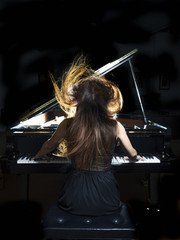 pianist performing on a grand concert piano