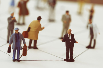 close up of miniature people with social network diagram on open