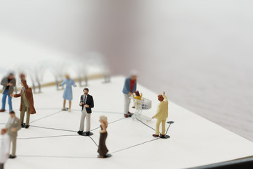 close up of miniature people with social network diagram on open