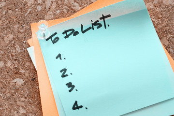 close up of pin and to do list word on sticky note with cork boa