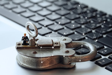 Internet security concept-miniature businessman stand on old key