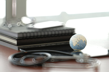 Studio macro of a stethoscope and texture globe with digital tab