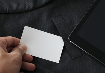 close up of hand picking blank business card from gray suit pock
