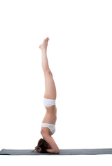 Side view of slender girl doing handstand