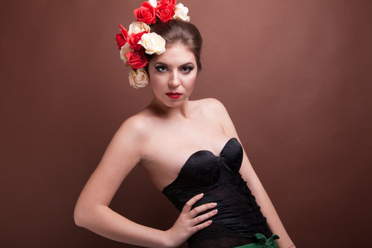 Woman with flowers in head on brown background