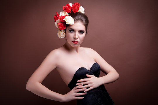Girl with flowers in her head on brown background