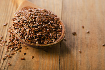 Flax seeds heap on a old  wooden spoon.
