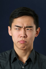Obraz premium Young Asian man making face and looking sideways