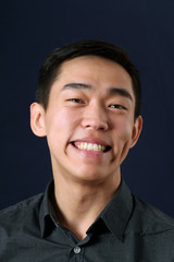 Fototapeta premium Laughing young Asian man looking at camera