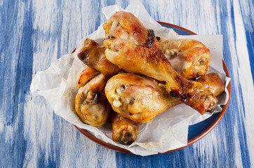 Roasted chicken legs on a blue plate
