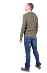 Back view of young man in t-shirt and jeans  looking.