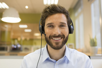 Smiling Businessman in the office on video conference, headset,