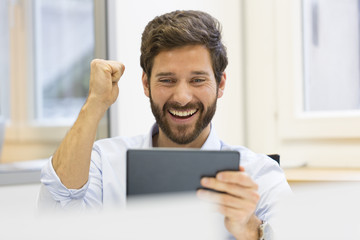 One joyful man holding digital tablet