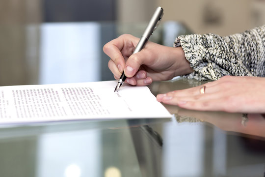 Close up of female hand signing formal paper
