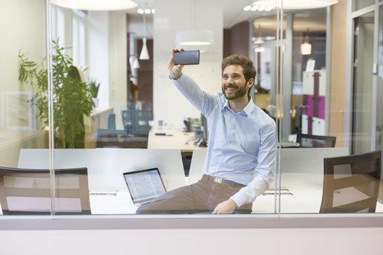 Selfie casual businessman taking pictures in open space office