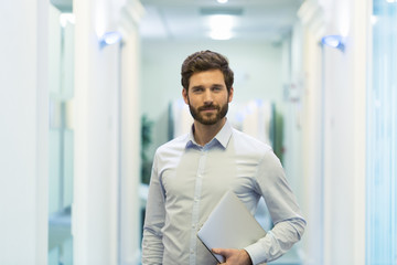 Portrait of handsome bearded business man in corridor office