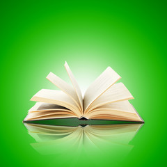 Opened book on bright green background
